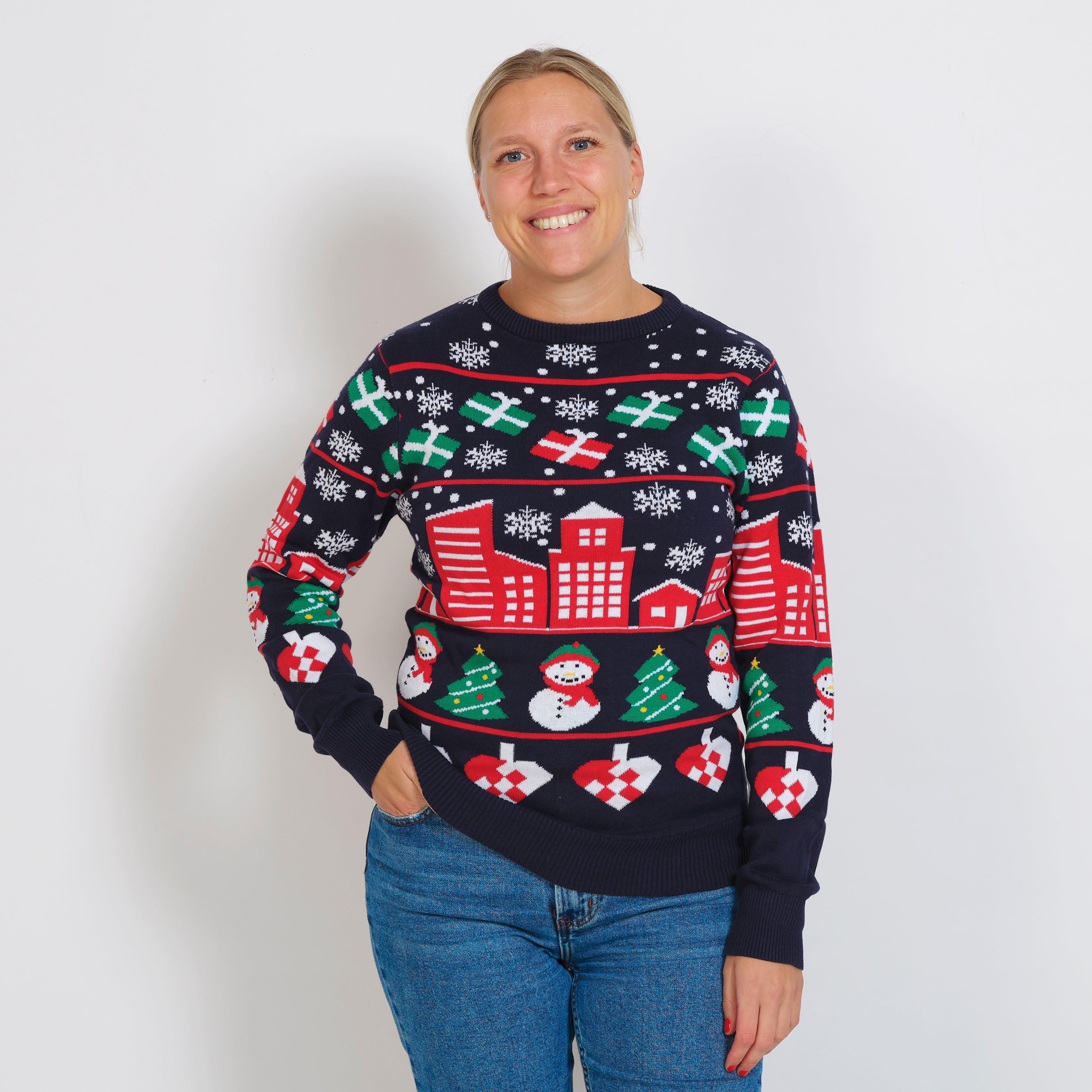 En kvinne iført julegenser med snøfnugg og gaver.